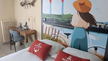Une chambre d’hôtel avec un lit, un bureau et une grande affiche représentant des phares.