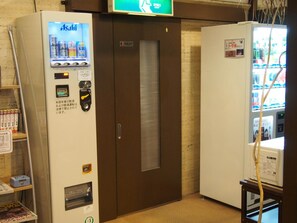 Ein Getränkeautomat und ein kleiner Kühlschrank mit Anzeige.