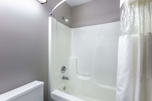 A bathroom with a bathtub, a shower, and a toilet. - Super 8 by Wyndham Delavan Near Lake Geneva (Delavan)