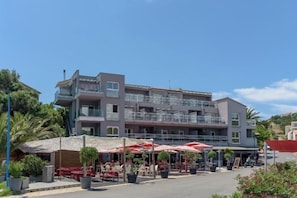 A multi-story hotel with outdoor seating and a covered area.