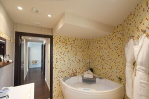 A bathroom with a large bathtub, tiled walls, and a visible shower area. - Hotel Le Golfe (Serra-di-Ferro)