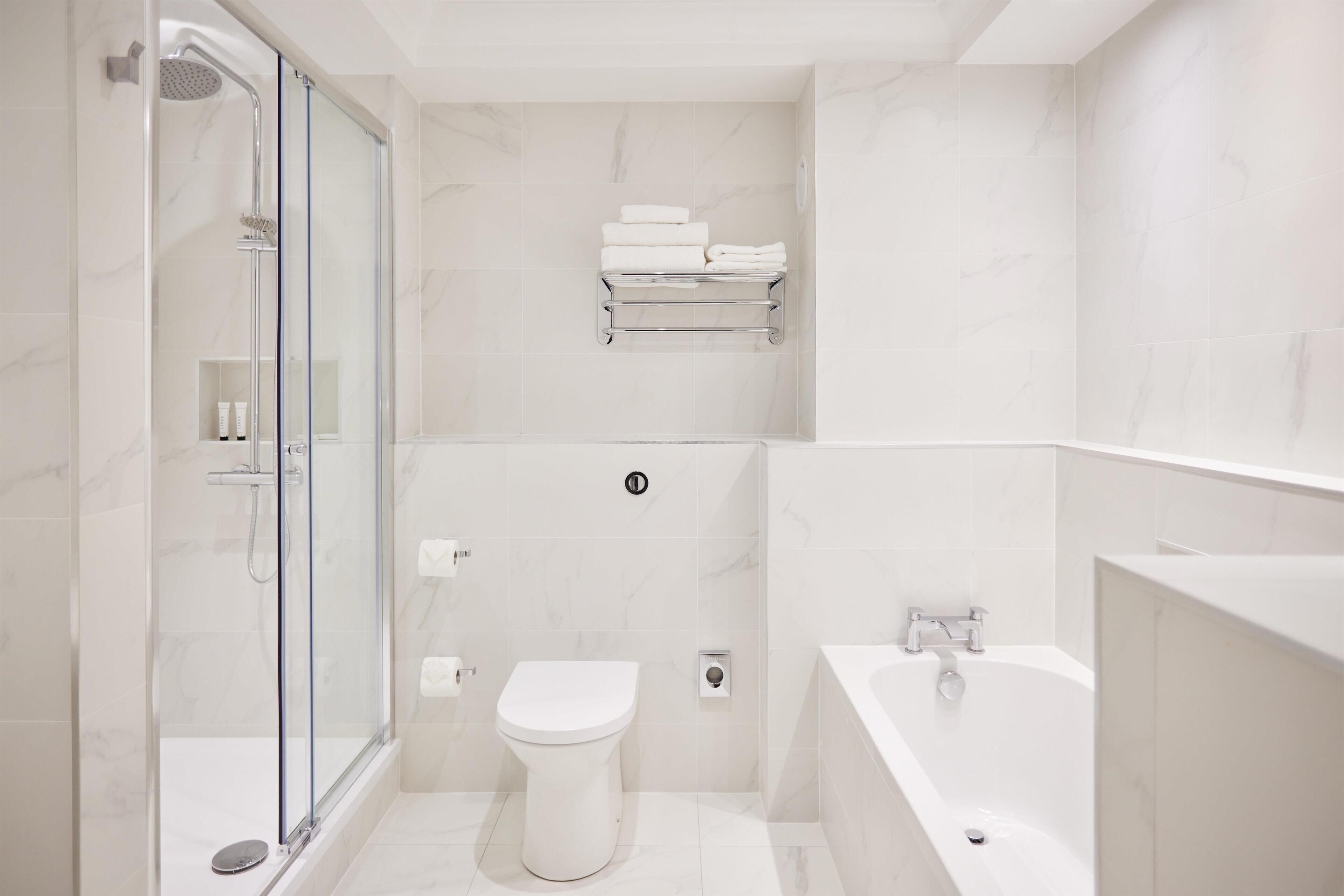 Une salle de bain moderne avec une douche à parois de verre, des toilettes et une baignoire.