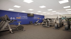 A gym with cardio equipment, weight machines, and a motivational wall. - Americinn by Wyndham Garden City (Garden City)