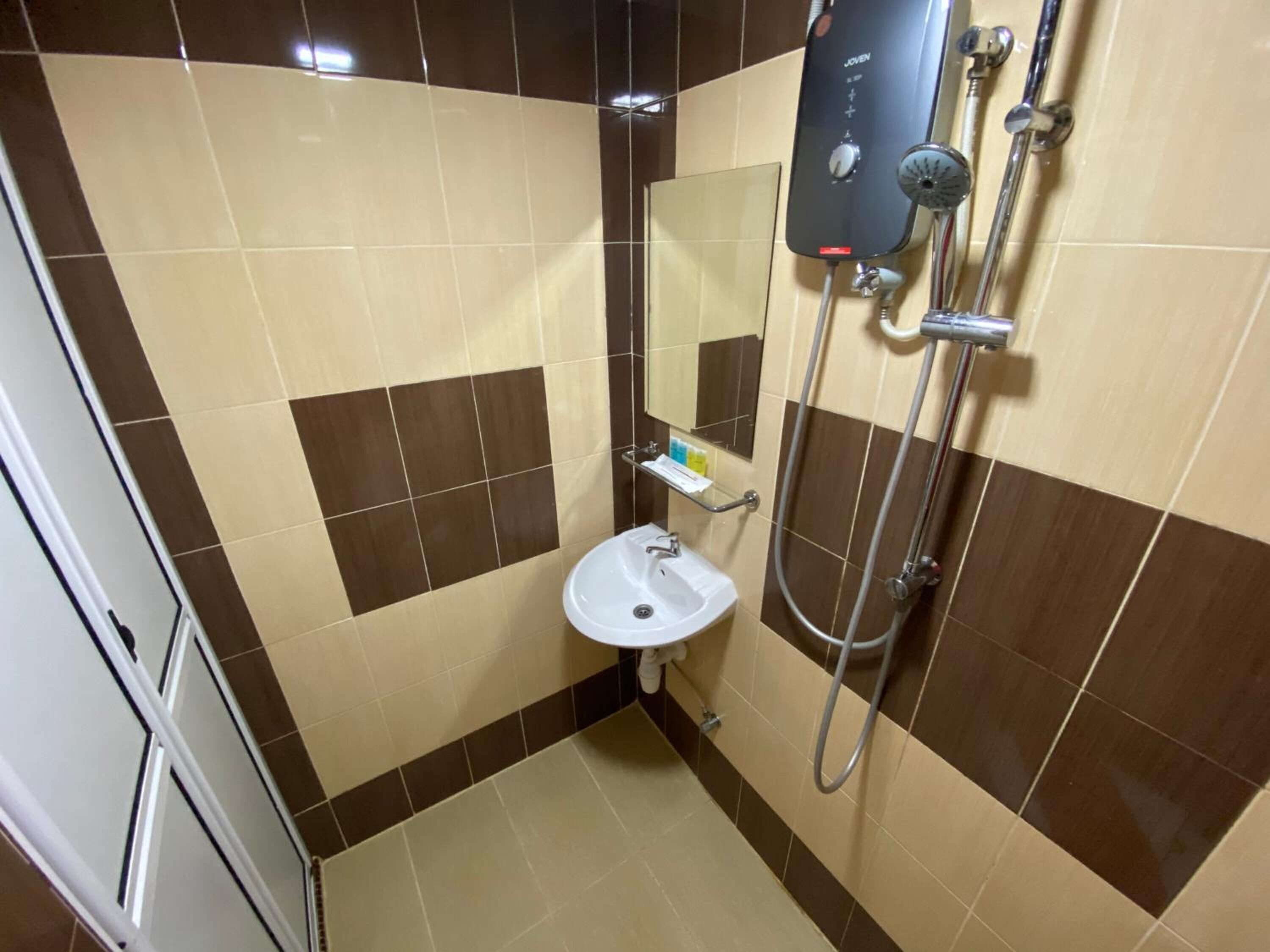 A bathroom with a shower, sink, and mirror.
