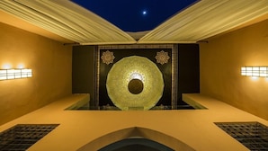 A room with a central decorative wall, recessed lighting, and a ceiling with draped fabric. - Adam Park Marrakech Hotel & Spa (Marrakech)