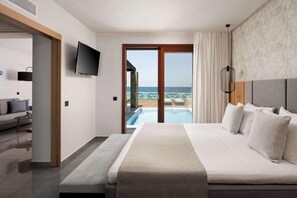 A hotel room with a bed, a TV, a balcony with a pool, and a view of the sea. - Ikaros Beach Luxury Resort and Spa - Adults Only (Hersonissos)