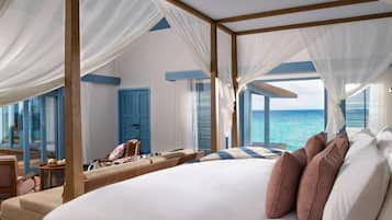 Un dormitorio con una cama grande, dosel y vista al océano.