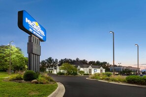 A Microtel Inn & Suites by Wyndham sign, a parking lot, and a building with a sign indicating a restaurant. - Microtel Inn & Suites by Wyndham Sunbury/columbus North (Sunbury)