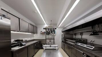 Una cocina moderna con electrodomésticos de acero inoxidable, una isla central e iluminación colgante.
