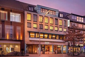 A multi-story hotel with a ground floor restaurant, multiple balconies, and a visible entrance. - Select Hotel Tiefenthal (Hamburg)