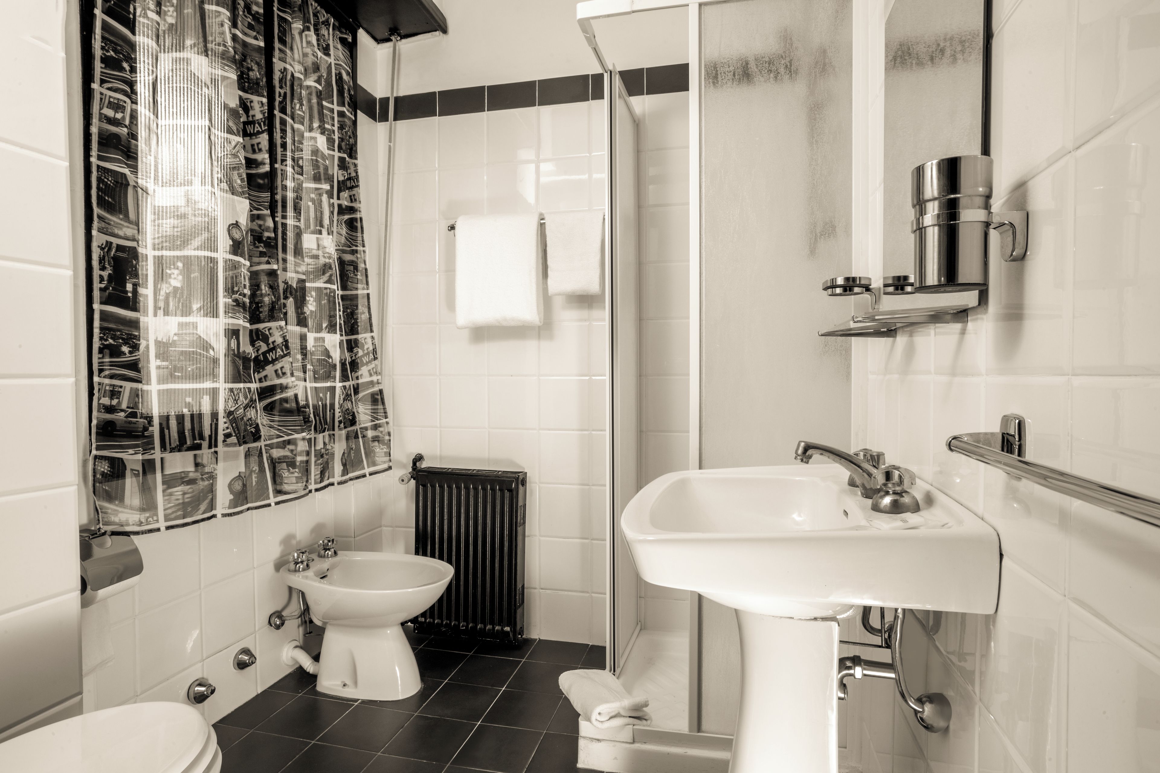 Un bagno con WC, bidet, lavandino e zona doccia.