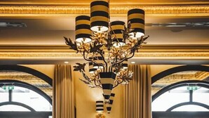 A dining area with a long table set for a meal, a chandelier, and large windows. - Kyniska Palace Conference and Spa (Sparta)