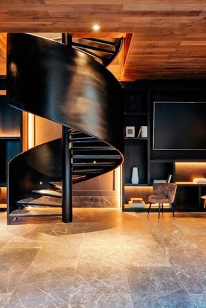A modern interior with a spiral staircase, a flat-screen TV, and a seating area. - Impression Moxché by Secrets Adults Only (Playa del Carmen)