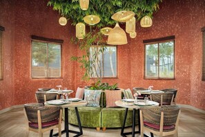 A restaurant with round tables, cushioned seating, and hanging lanterns. - Sunscape Dominicus La Romana (San Rafael del Yuma)