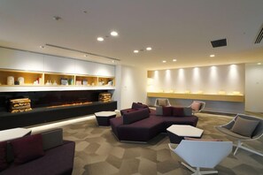 A modern lounge area with sofas, a coffee table, and a fireplace. - Tenza Hotel & Sky Spa Sapporo Central (Sapporo)