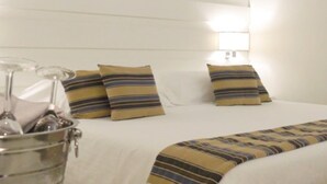 A hotel room with a bed, pillows, a bedside lamp, and a metal bucket. - Sunshine Club Hotel & Spa (Ricadi)