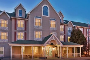A multi-story hotel with a central entrance, multiple windows, and a covered front porch. - Country Inn & Suites by Radisson, Birch Run-frankenmuth, MI (Birch Run)
