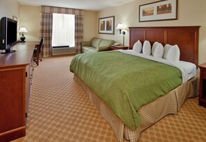 A hotel room with a bed, desk, chair, TV, and two lamps. - Country Inn & Suites by Radisson, Birch Run-frankenmuth, MI (Birch Run)