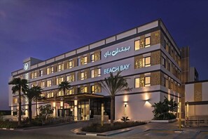 A multi-story hotel with a modern design, featuring a prominent 'Beach Bay' sign.
