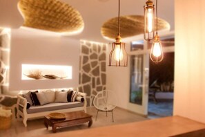 A modern living room with a sofa, a coffee table, and hanging light fixtures. - Malibu Boutique Studios (Rhodes)