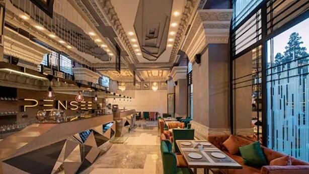 A spacious hotel lobby with a bar area, seating arrangements, and a view through large windows. - Stars Hotel and Spa (Marrakech)