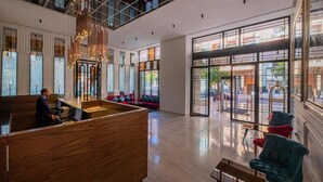 A modern hotel lobby with a reception desk, seating area, and large windows offering views of the street. - Stars Hotel and Spa (Marrakech)
