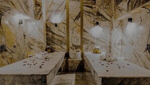 A marble-floored spa with two treatment tables, each with towels and rose petals. - Stars Hotel and Spa (Marrakech)