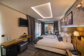 Ein Hotelzimmer mit Bett, Schreibtisch und Fernseher.