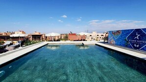A clear swimming pool with lounge chairs and a Stars Hotel advertisement. - Stars Hotel and Spa (Marrakech)