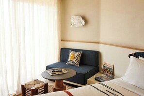 A hotel room with a bed, a sofa, a small round table, and a window with curtains. - Fenix Hotel (Glyfada)