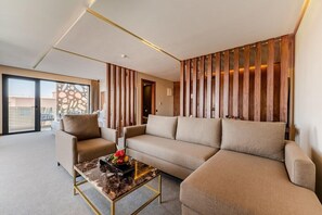 A modern living room with a sofa, armchairs, a marble coffee table, and a wooden slat wall. - Longue Vie Hotel Marrakech (Marrakech)
