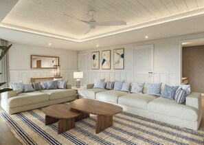 Una sala de estar moderna con un sofá modular, una mesa de centro y un ventilador de techo.