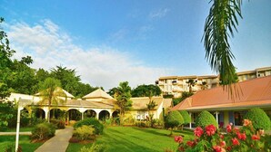 A courtyard with a pathway, a building with a red roof, and a palm tree. - Secrets St. Lucia Resort & Spa Adults Only (Gros Islet)