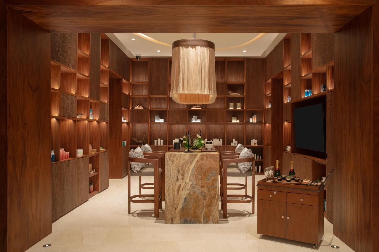 A modern interior with a marble-topped table, bar stools, and a television.
