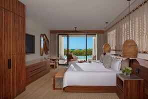 A modern hotel room with a large bed, a desk, a chair, and a view of the ocean. - Secrets Playa Blanca Costa Mujeres (Costa Mujeres)