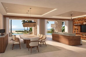 A spacious living area with a large dining table, comfortable seating, a built-in entertainment unit, and a view of the ocean. - Secrets Playa Blanca Costa Mujeres (Costa Mujeres)