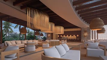 A modern lounge area with wooden furniture, hanging light fixtures, and a view of palm trees.