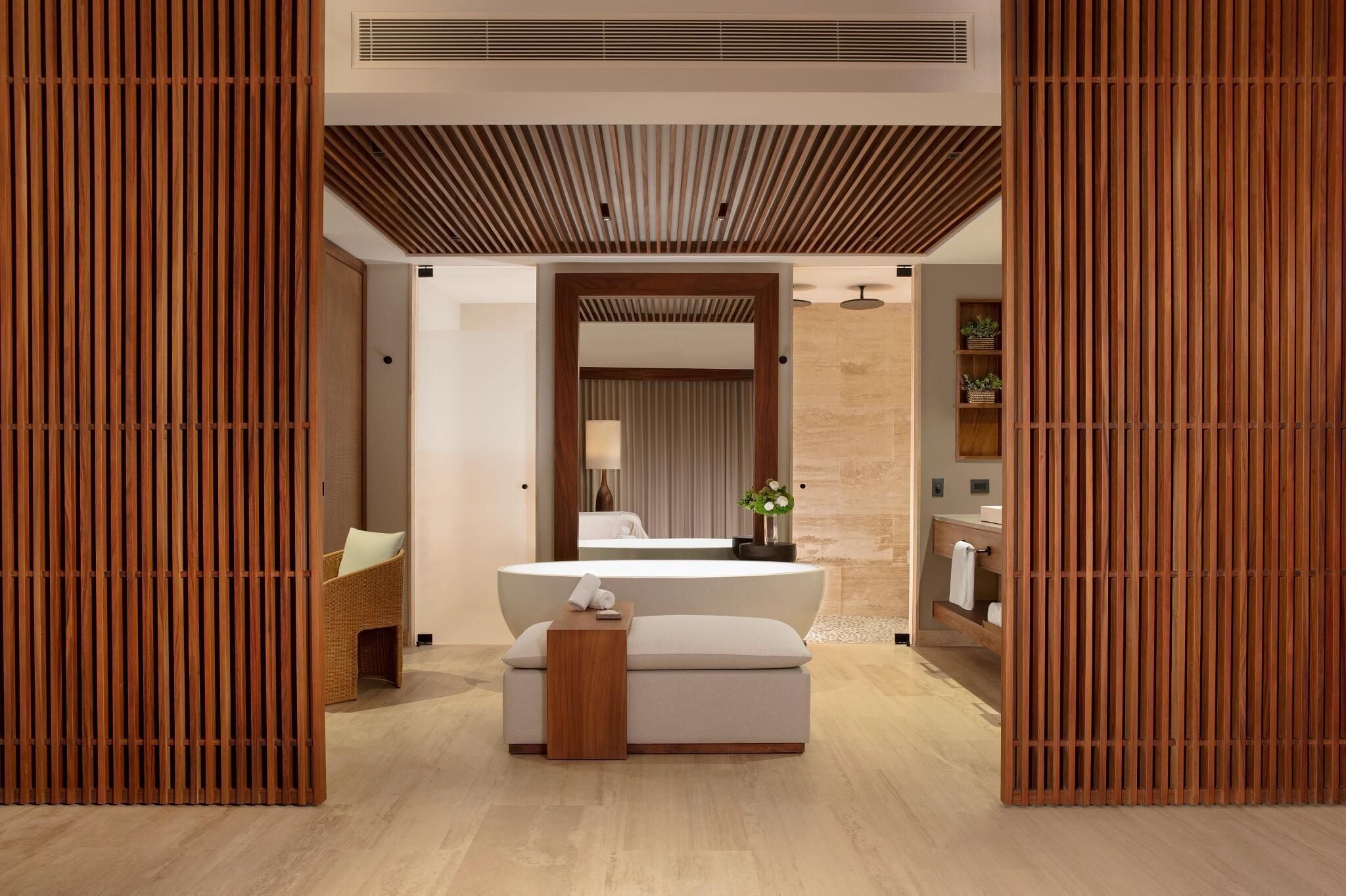 Un baño moderno con un lavamanos central, un espejo y una separadora de madera.