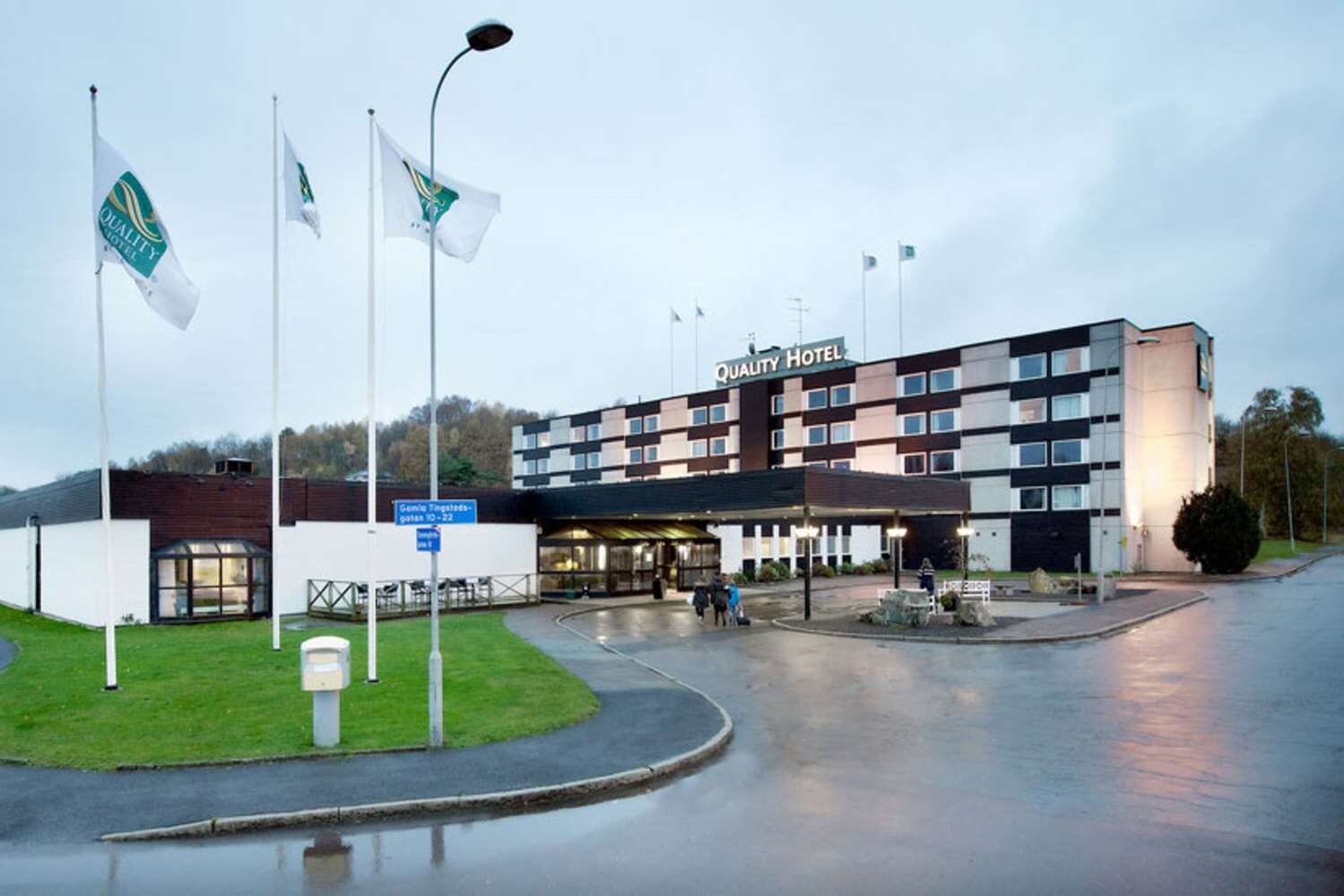 Un hotel de diseño moderno, con una entrada destacada y varias banderas.
