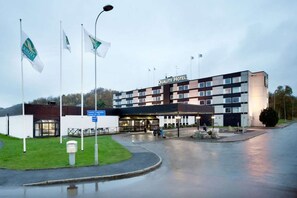 A hotel with a modern design, featuring a prominent entrance and multiple flags. - Quality Hotel Winn (Hisings Backa)