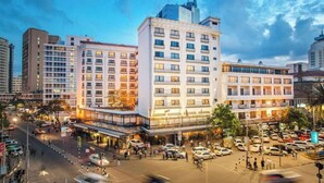 A multi-story hotel with a modern facade, located in a busy urban area with a parking lot and street view. - Sarova Stanley (Nairobi)