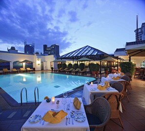 A rooftop pool area with lounge chairs, tables set for dining, and a glass-roofed structure. - Sarova Stanley (Nairobi)
