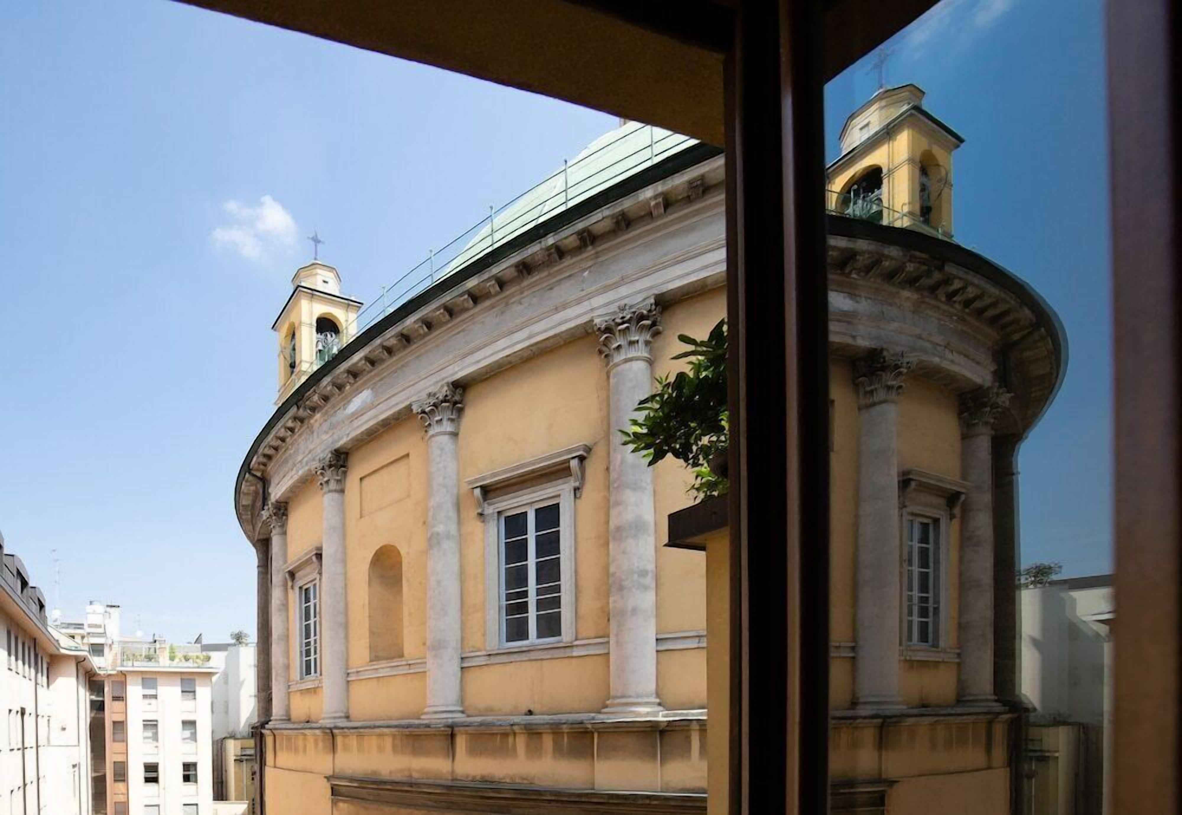 A classical building with columns, arched windows, and a balcony.