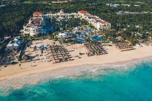 Un resort con playa, piscina y varios edificios.