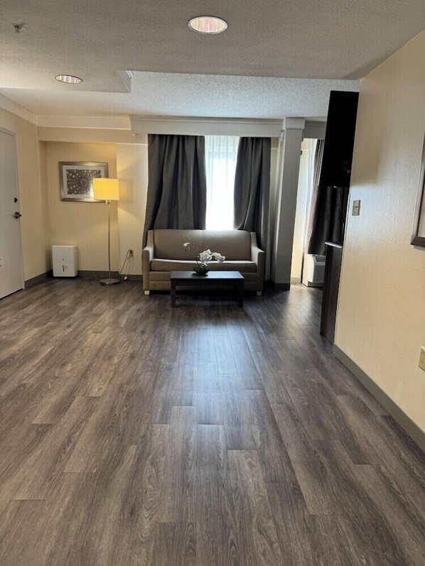 Un salon moderne avec un canapé, une table basse, une lampe et un tableau au mur.
