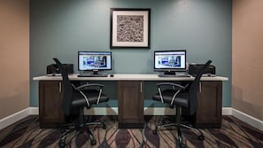 A conference room with two desktop computers, black office chairs, and a framed picture on the wall. - Spark by Hilton Fort Myers (Fort Myers)