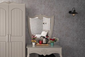 A room with a large wardrobe, a mirror, a table with a kettle, a red mug, and flowers. - Viva Hotel Oldcity (Istanbul)