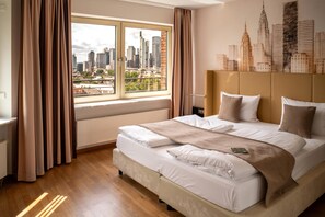 Ein Hotelzimmer mit einem großen Bett, Blick auf die Stadt und einem anliegenden Kopfteil mit Stadtbild-Wandgemälde.