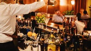 Un barman verse une boisson dans un verre à martini.
