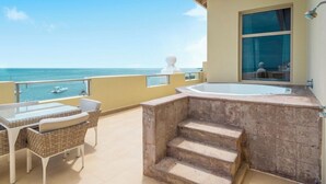 A balcony with a view of the sea, a hot tub, and a table with chairs. - Iberostar Waves Rose Hall Beach All Inclusive (Montego Bay)